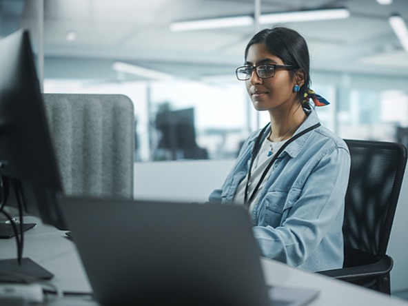 young woman working at a computer screen in office 